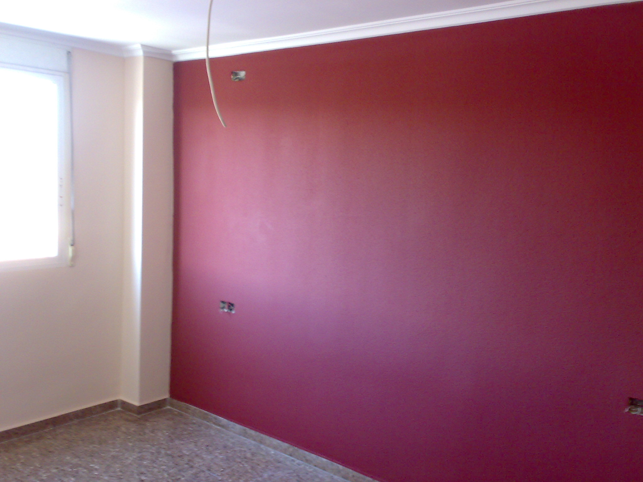 Pared pintada en color burdeos con acabados profesionales